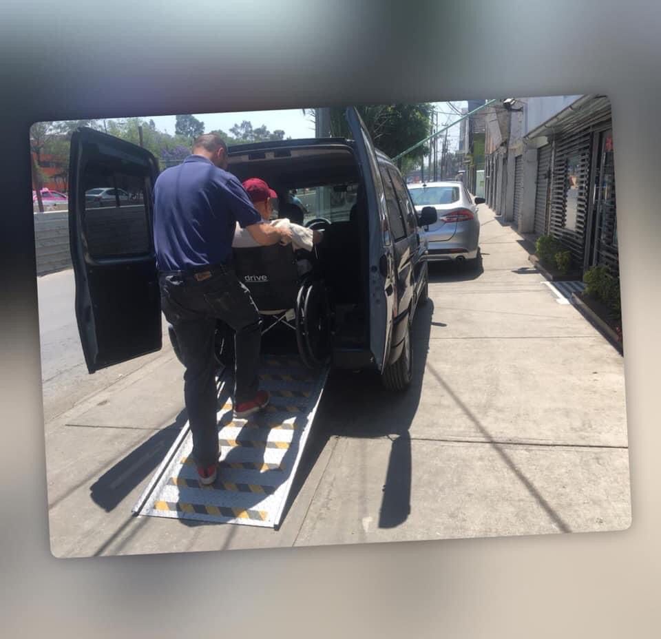 Personal apoyando el ascenso de un paciente a la unidad de transporte